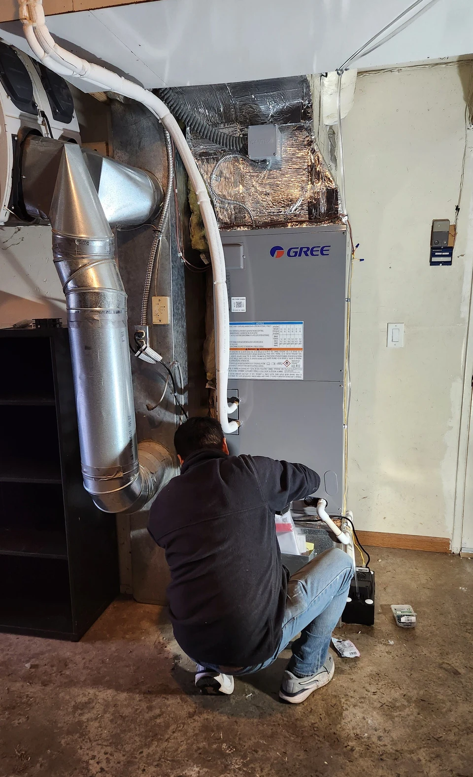 Technician working at a GREE indoor air handler in Newcastle